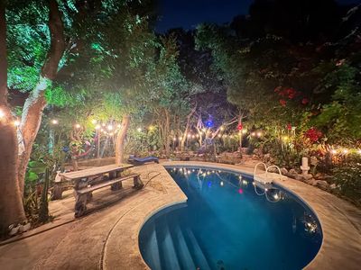 The pool and garden lit up at night
