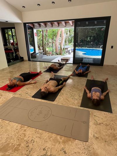 A group practising in the marble-floored yoga space